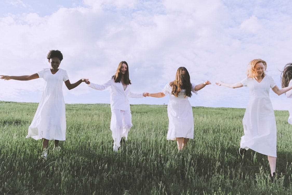 Girls in white dance in a clearing